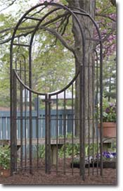 Classic wrought iron arbor with a gate.